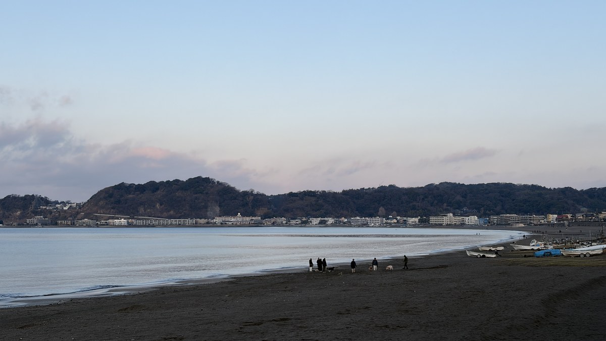 夕暮れの静かな海と数人の人影
